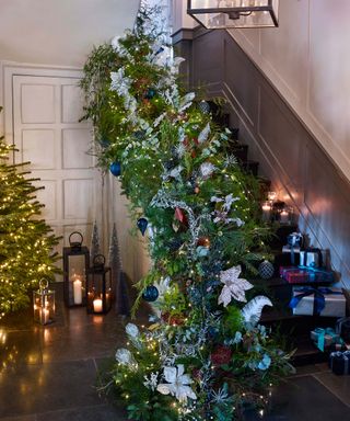 blue themed christmas garland and presents up a flight of stairs