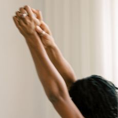 Woman stretching and practicing basic Pilates moves at home