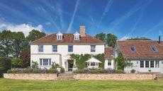 Large period property with brick roof, white painted facade and walled garden
