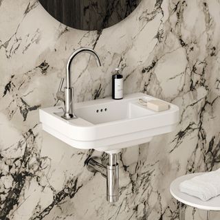 A modern bathroom with marble walls and a white floating sink