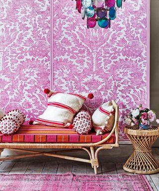 Bohemian living room ideas example with pink walls, wicker sofa and side table