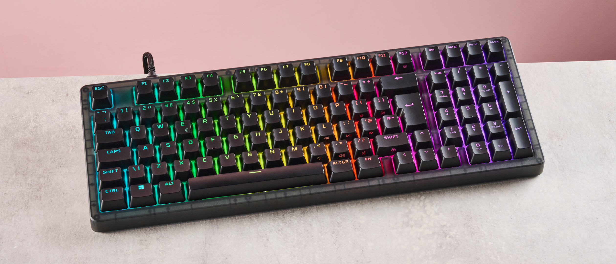 Top-down view of HyperX Origins 2 1800 with RGB backlighting on, on a desk with pink wall in background