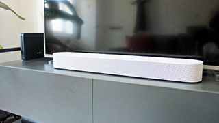 the sonos beam gen 2 soundbar in white on a tv cabinet under a TV display