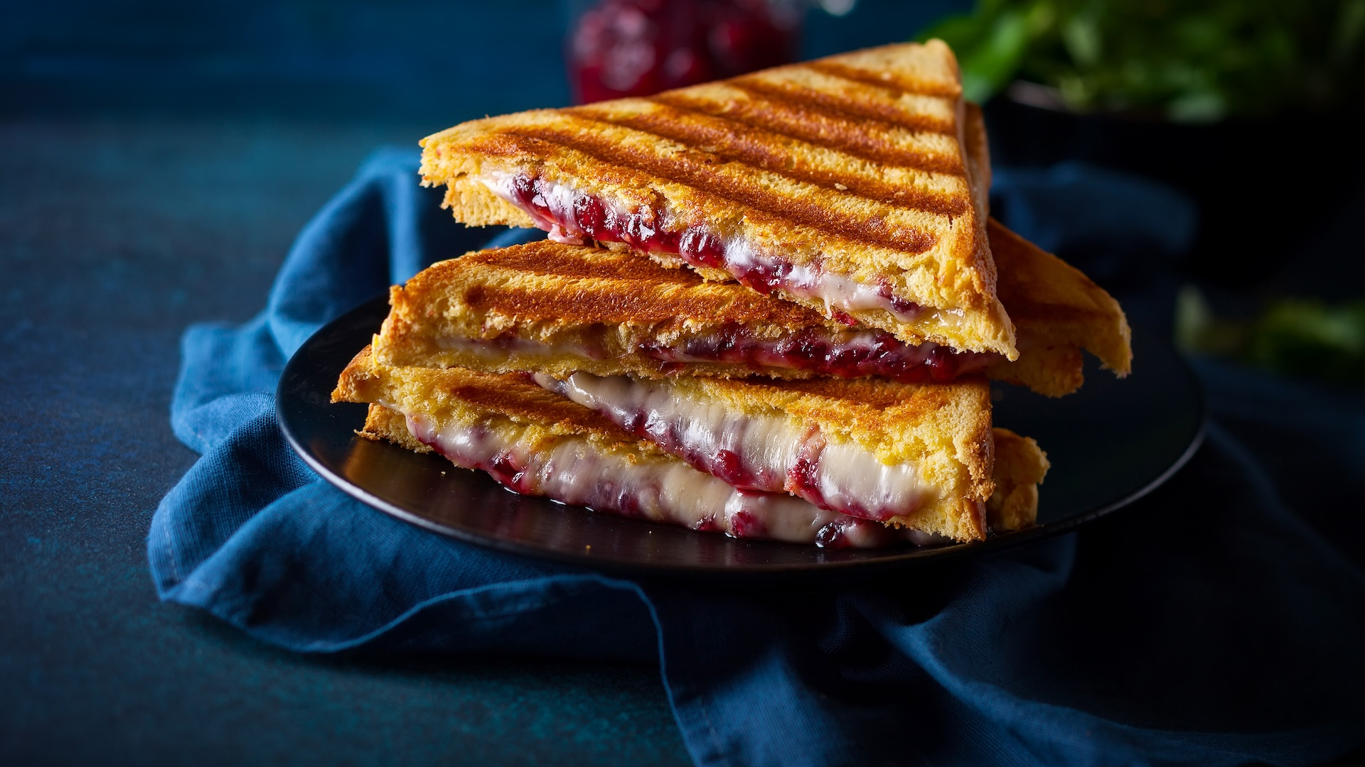 Grilled sandwiches with cheese, ham and cranberry chutney on plate