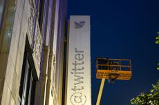 Workers take blue bird and the letters off from Twitter sign on headquarters