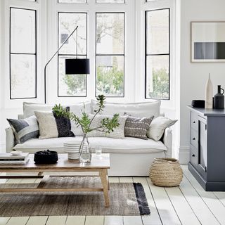 Black and white living room with black framed windows and white sofa