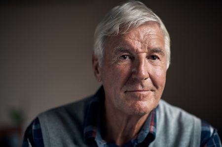 A man in his 70s faces the camera with a slight smile.