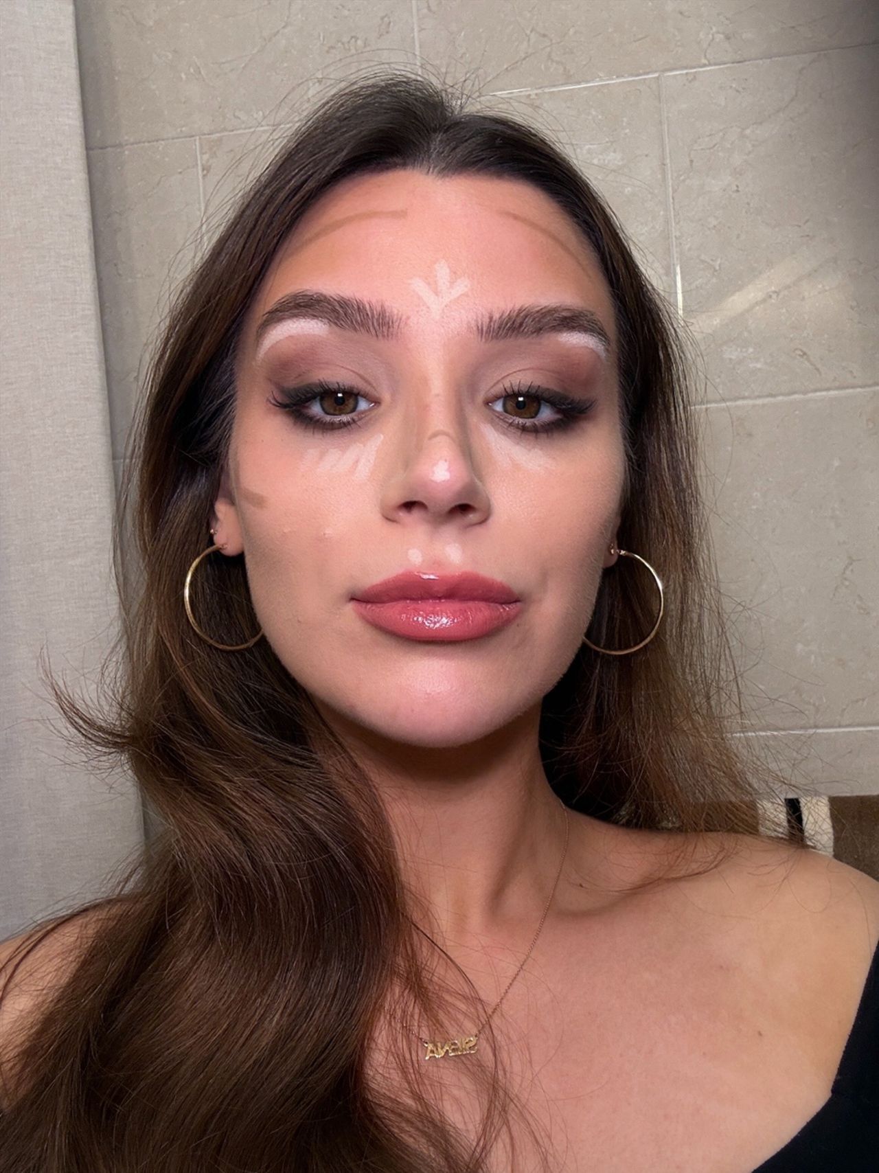 Close-up selfie of me with contour and highlight mapped onto my forehead, cheeks, nose, under-eyes, and brow bone before blending.