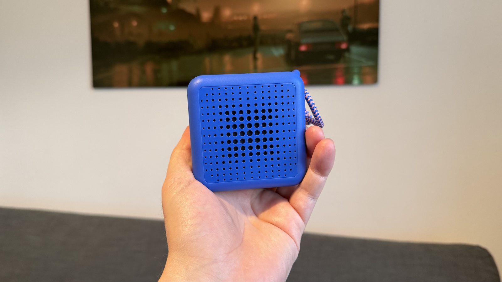 A small, Blue Ikea speaker, photographed in someone's hand