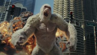 George stands roaring in front of an explosion in Rampage.