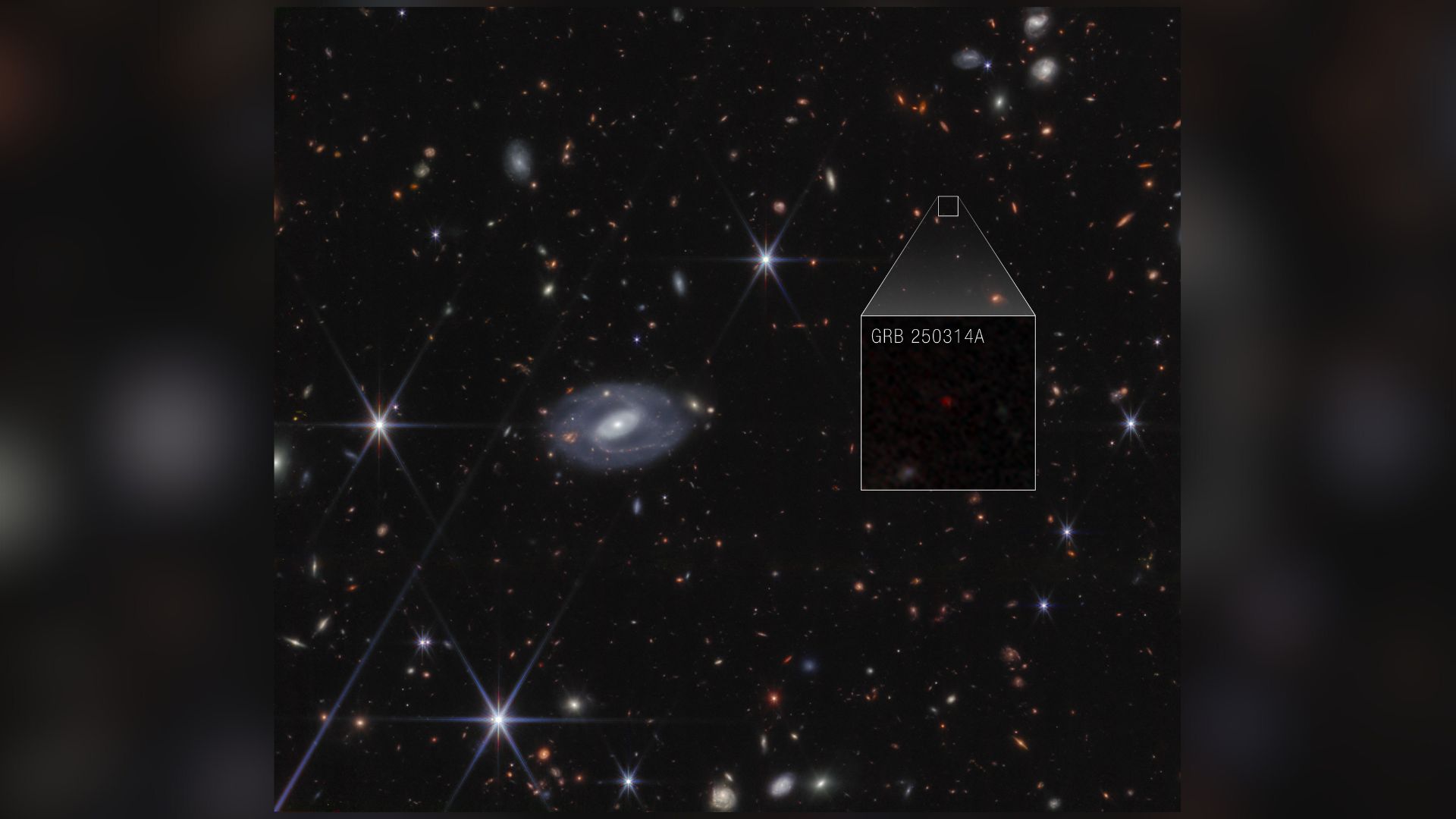 A deep space image showing various colored stars and galaxies, with a boxout showing a supernova with the label GRB 250314A, in white text