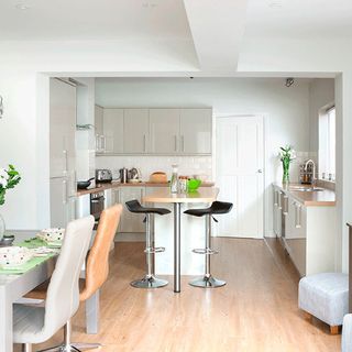 kitchen diner with white cabinet and wooden flooring