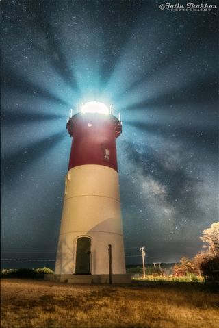 The Milky Way shines behind the Nauset Lighthouse in Eastham, Massachusetts. Taken on July 2, 2016, this night sky photo captures the rotating light beams radiating in all directions from tower, with the Milky Way tucked between two streams of light.