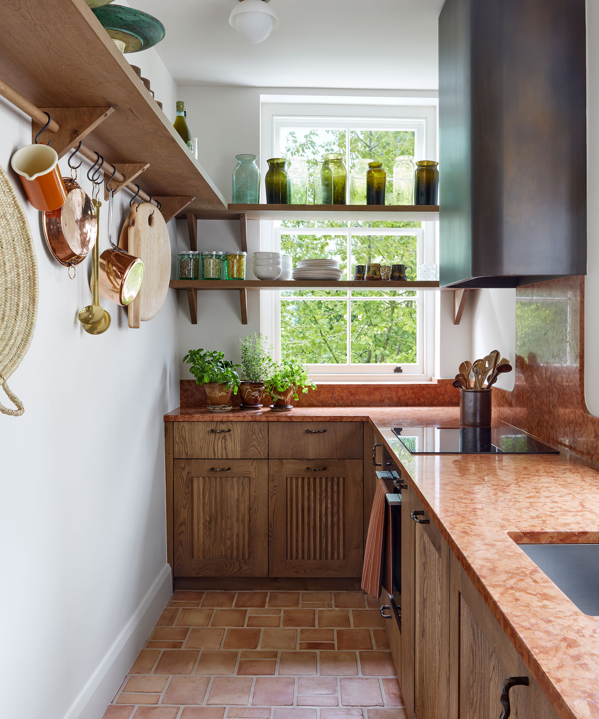 small wooden kitchen with granite worktop and quarry tiled floor