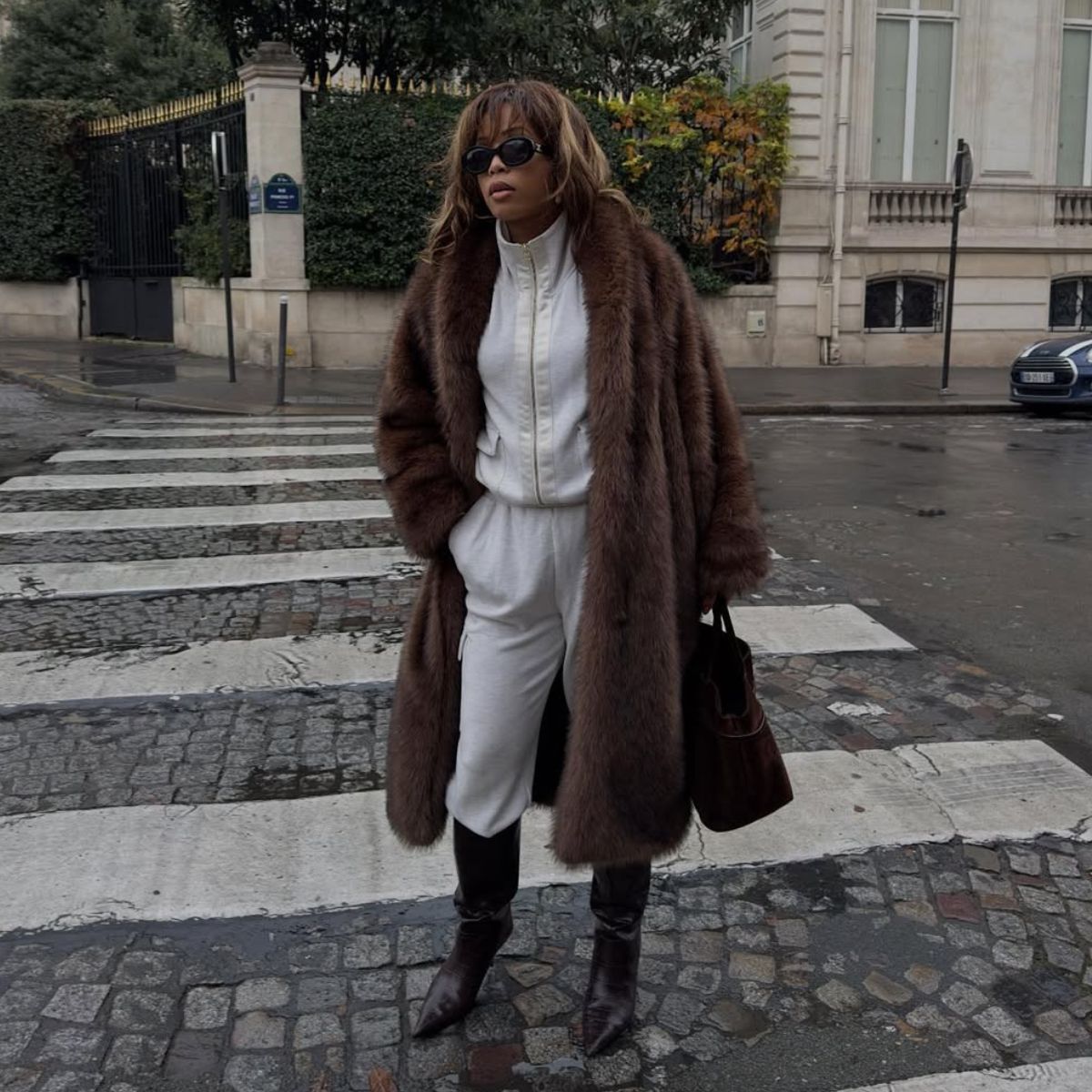 Ellie Delphine wears track pants with a faux fur coat.