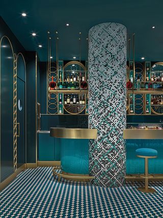Liòn restaurant with column studded with mosaic tiles and two toned square floor tiles