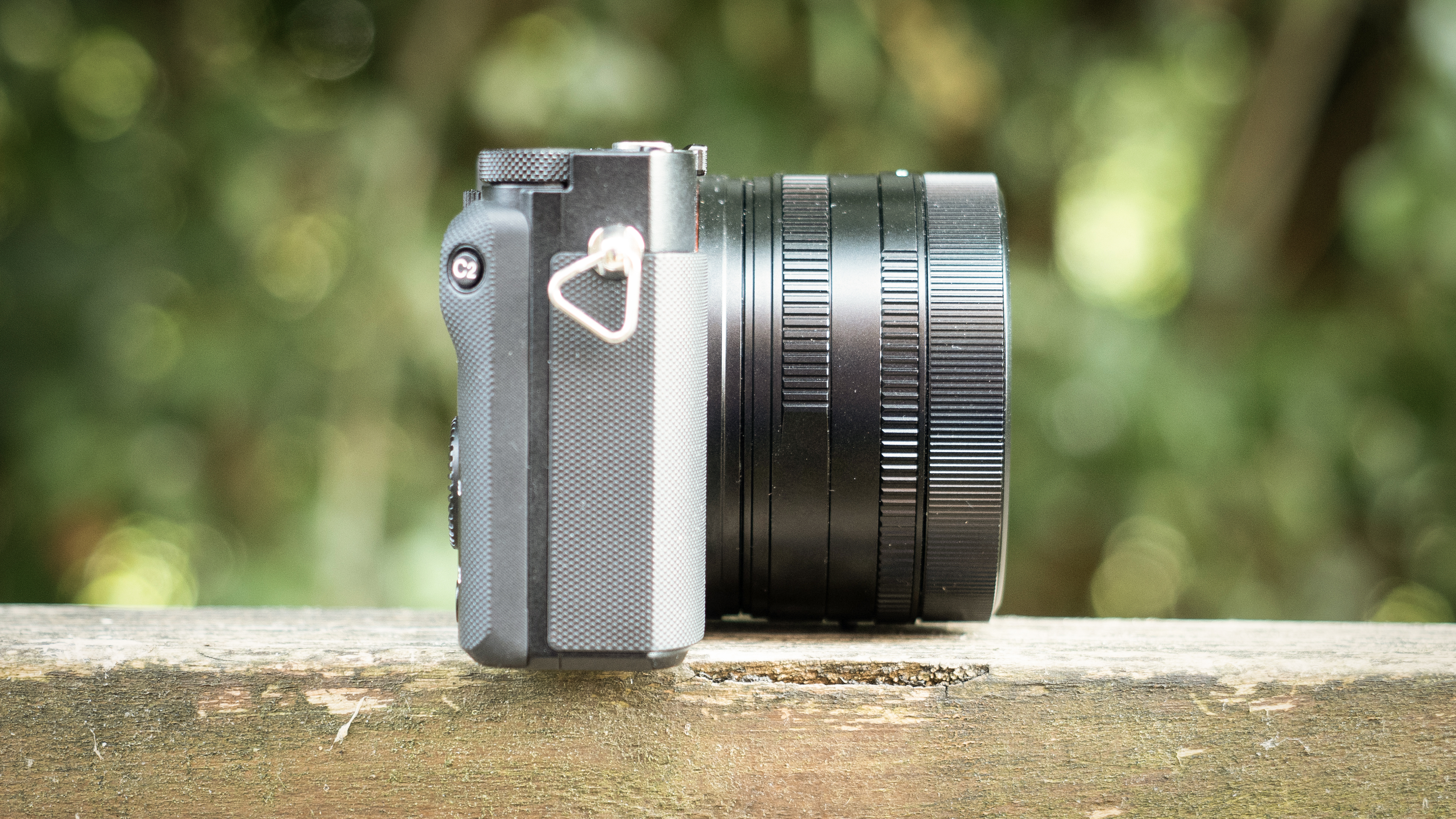Sony RX1R III on a wooden surface in a woodland environment