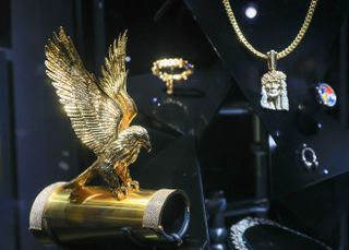 A gold eagle and Jesus pendant once owned by Notorious B.I.G. on display at "Ice Cold: An Exhibition of Hip-Hop Jewelry" at the American Museum of Natural History in New York City