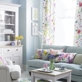 blue living room with floral curtain and white dresser