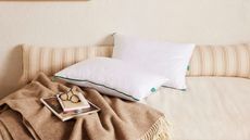 The Marlow Pillow on a bed with blankets and throw pillows.