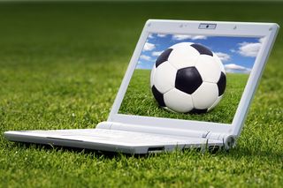 Laptop on grass with image of football