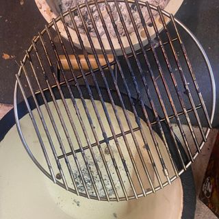 Kamado Maxi Ceramic Charcoal BBQ during the cleaning process, removed grill pan and concrete bowl with ash