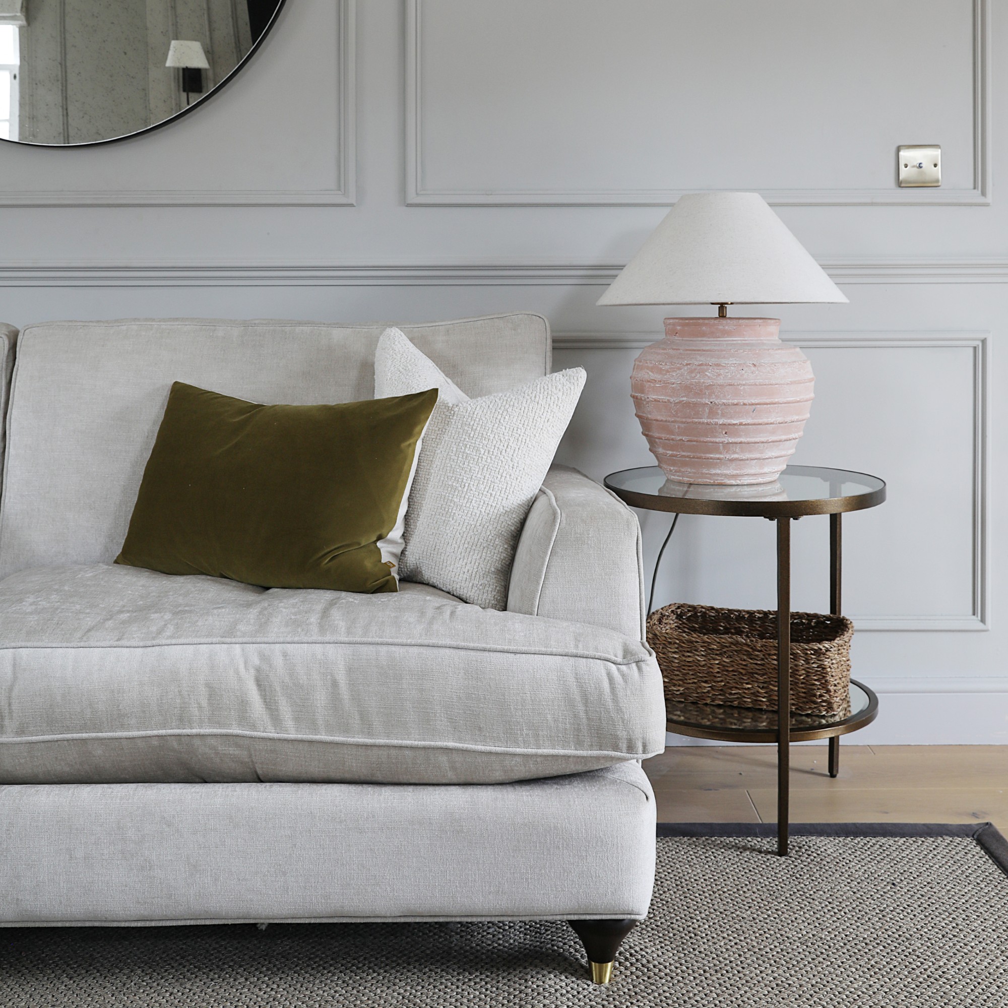 A grey living room with panelled walls and an ivory sofa