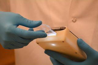 A technician operates a smartphone device that can detect abnormal semen samples with 98 percent accuracy. 