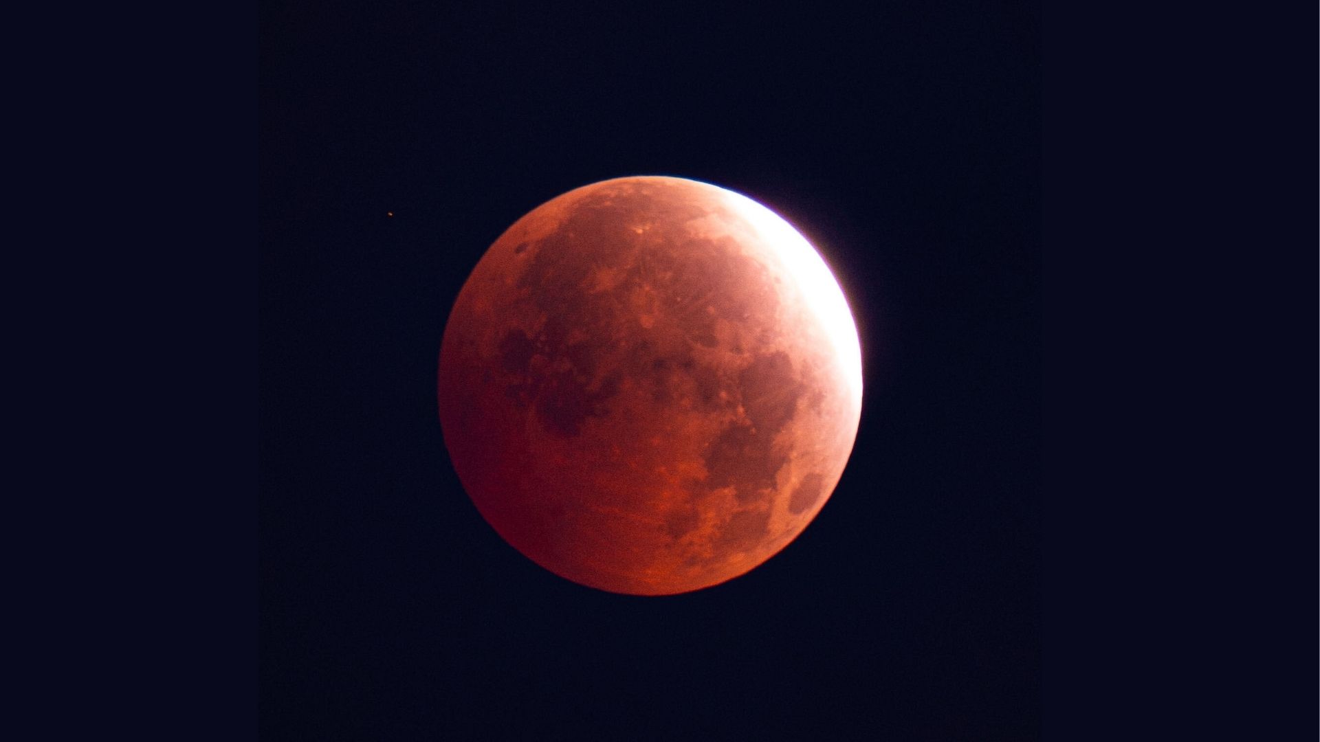 A full moon is photographed in a black sky during a lunar eclipse.