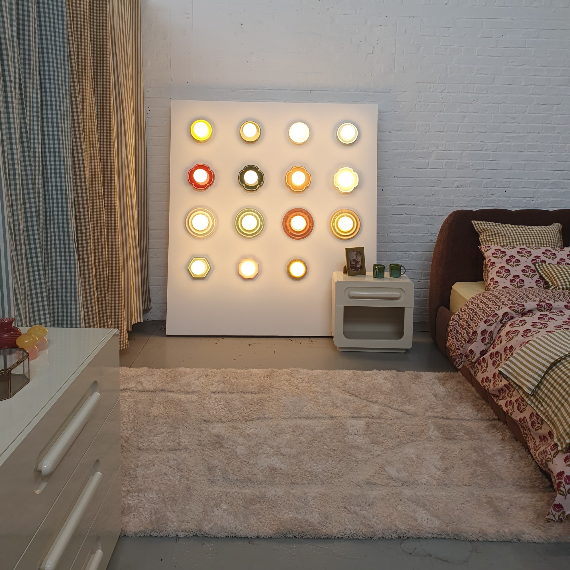 A bedroom set up at the La Redoute HQ in Lille, France with a wall displaying the brand's bestselling wall lights