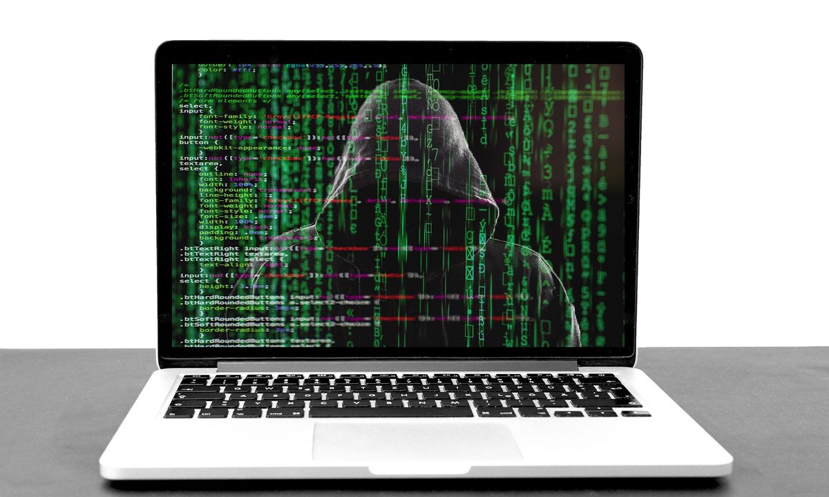 Laptop with representation of a hacker on screen with code