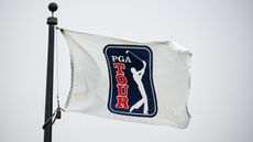 A PGA Tour flag being blown about in strong winds
