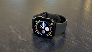 The Apple Watch 8 on a blue desk and wrist