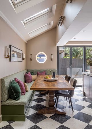 kitchen side extension with black and white chequerboard flooring and bench seating with bifold doors to outside