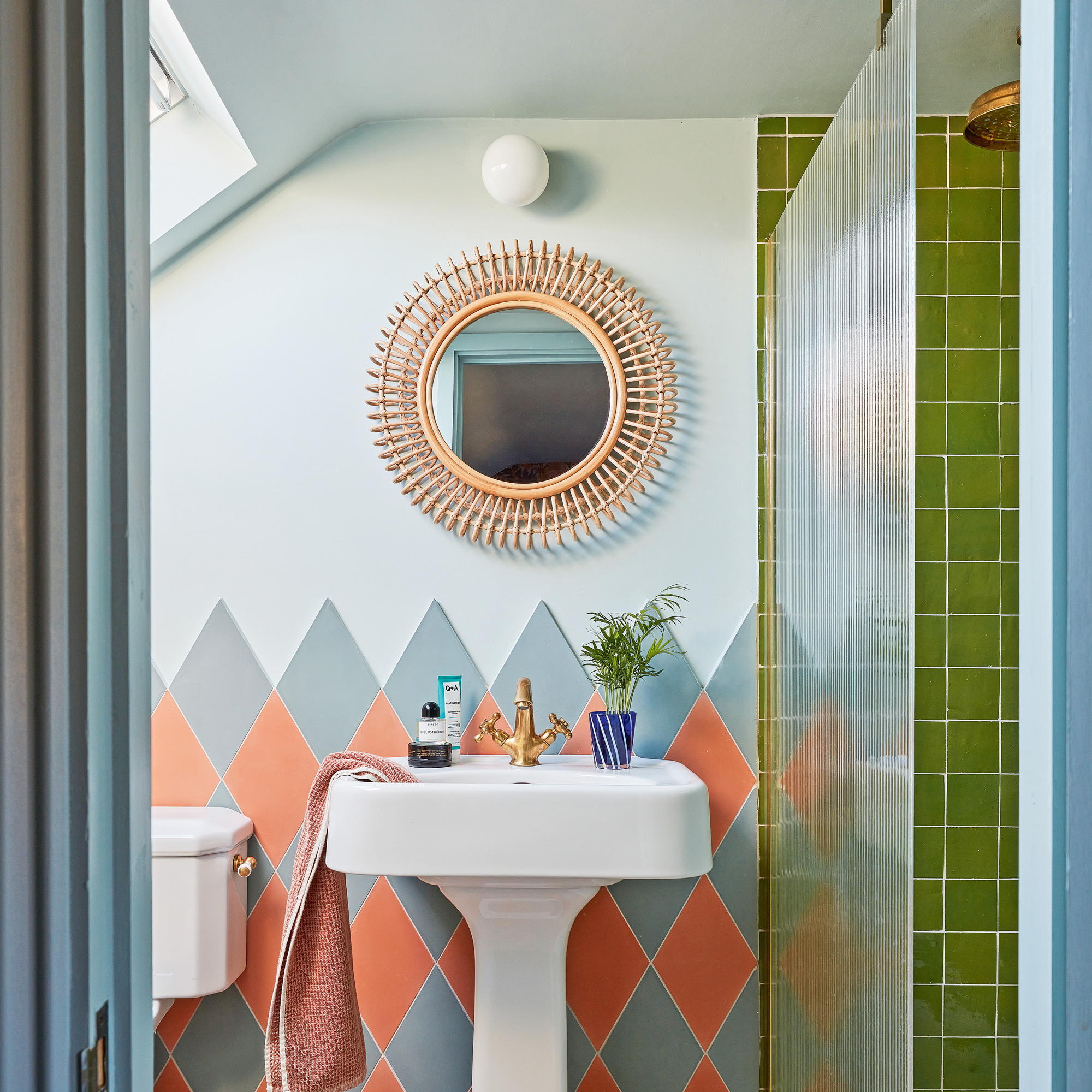 bathroom with green tiled walk-in shower and coral and grey tiled basin splashback