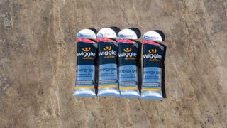 Four Wiggle Nutrition energy gels on a paved floor