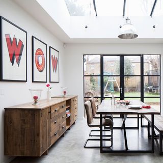 dining area with white wall and concrete floor and dining table