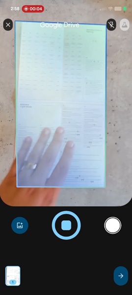 A snapshot of Google Drive&#039;s new AI scanner for documents, which now displays a colored outline when it&#039;s identified pages and a new &amp;quot;stop&amp;quot; or pause button right under its viewfinder.