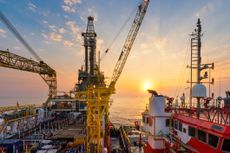 offshore oil drilling rig platform in ocean at sunset