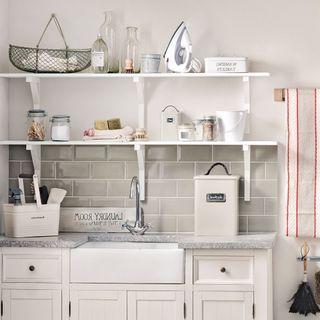white shelf on white wall with white drawers and wash basin
