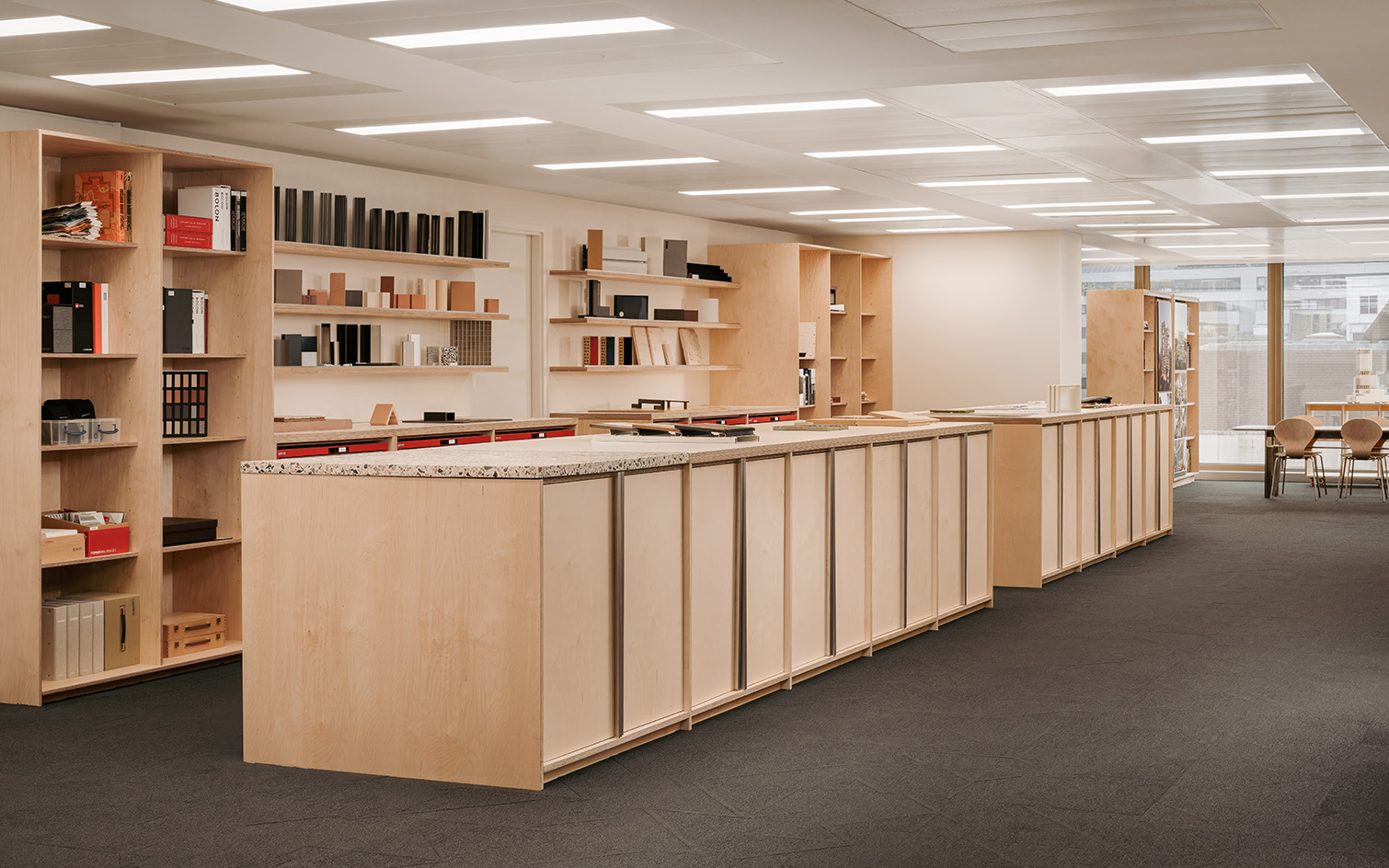 PLP Architecture&#039;s circular office design in neutral colours and soft light, showing empty workspace and timber seating and desks