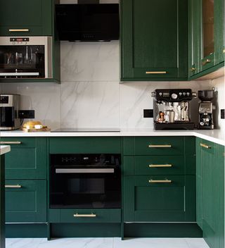 Green kitchen cabinets with white worktops