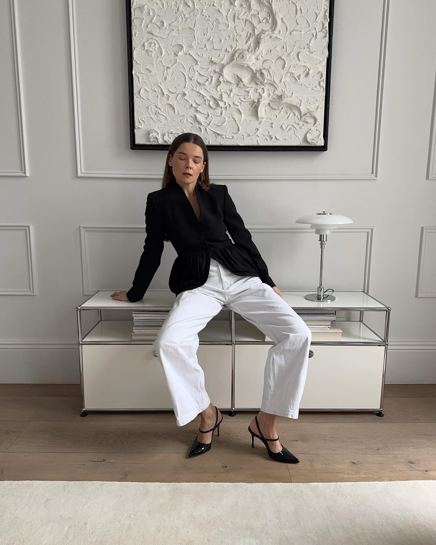 An image of @rikkekrefting wearing a waisted blazer and wide-leg trousers with pointed-toe heels.