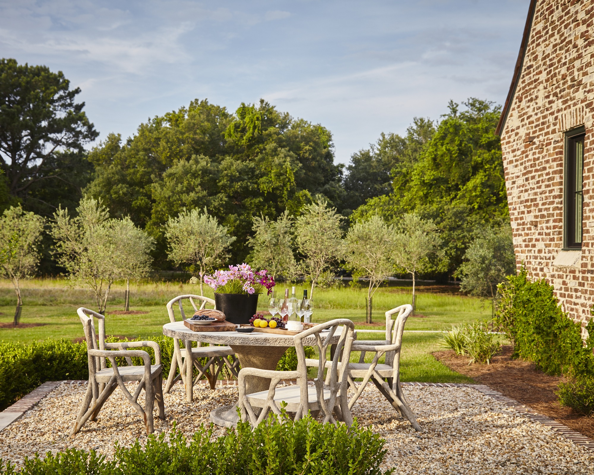 A cottage garden with tree-branch inspired dining table and chairs