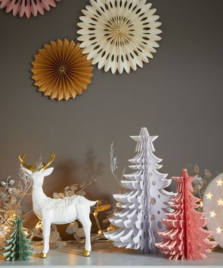 Paper trees with white deer ornament on Christmas setup