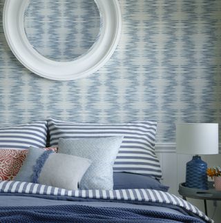 Blue bedroom with striped bedding and patterned wallpaper