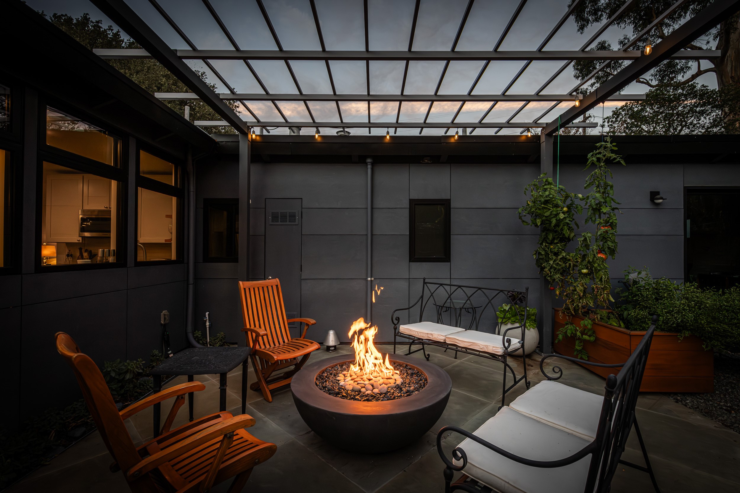 A firepit sits in the middle of a garden patio
