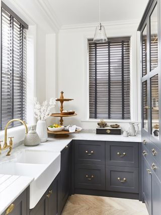 gray basswood blinds in small kitchen with white walls and dark gray cabinetry