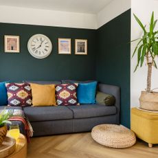 living room with green wall and grey sofa