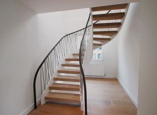 Open Riser staircase in mild steel with hand stitched grey leather handrail